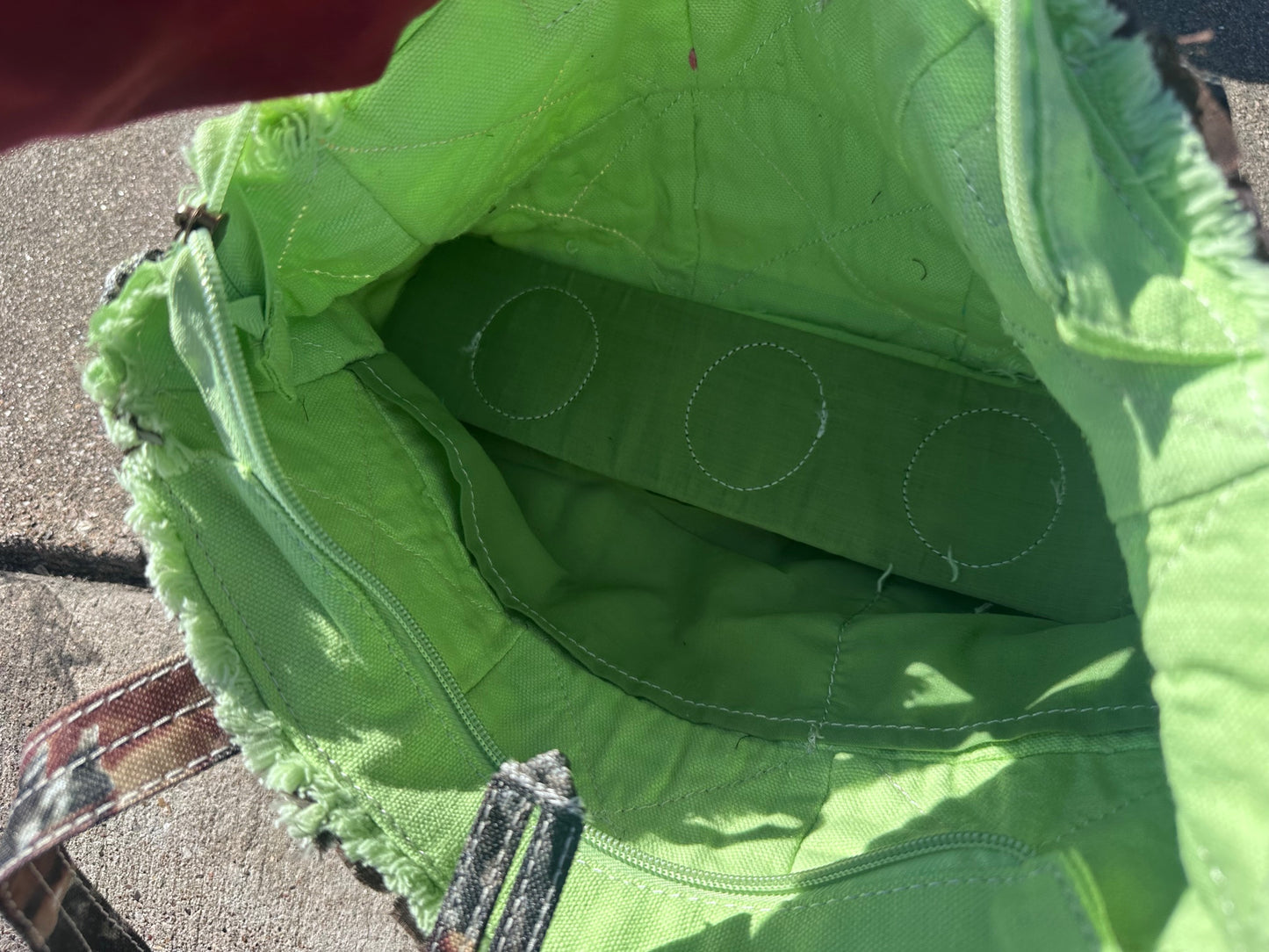 Close-up of a green jacket with a zipper, showing the interior lining.