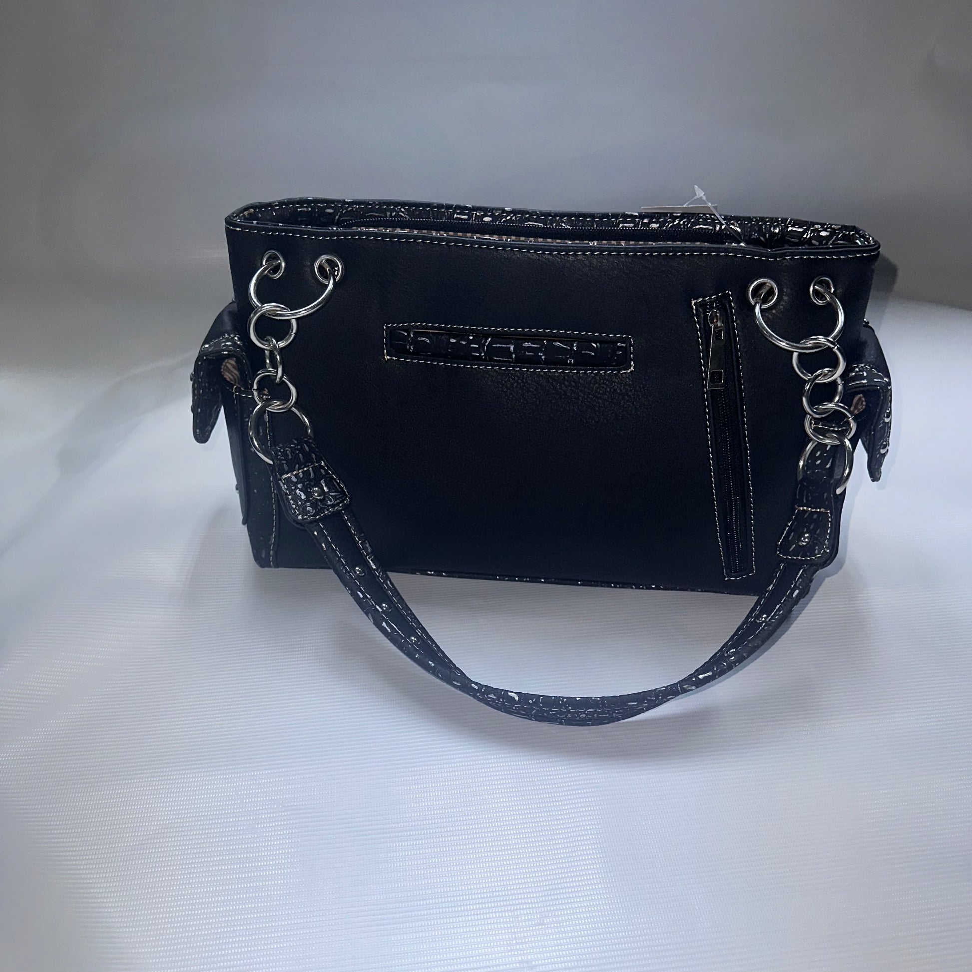 Black handbag with silver hardware on a white background