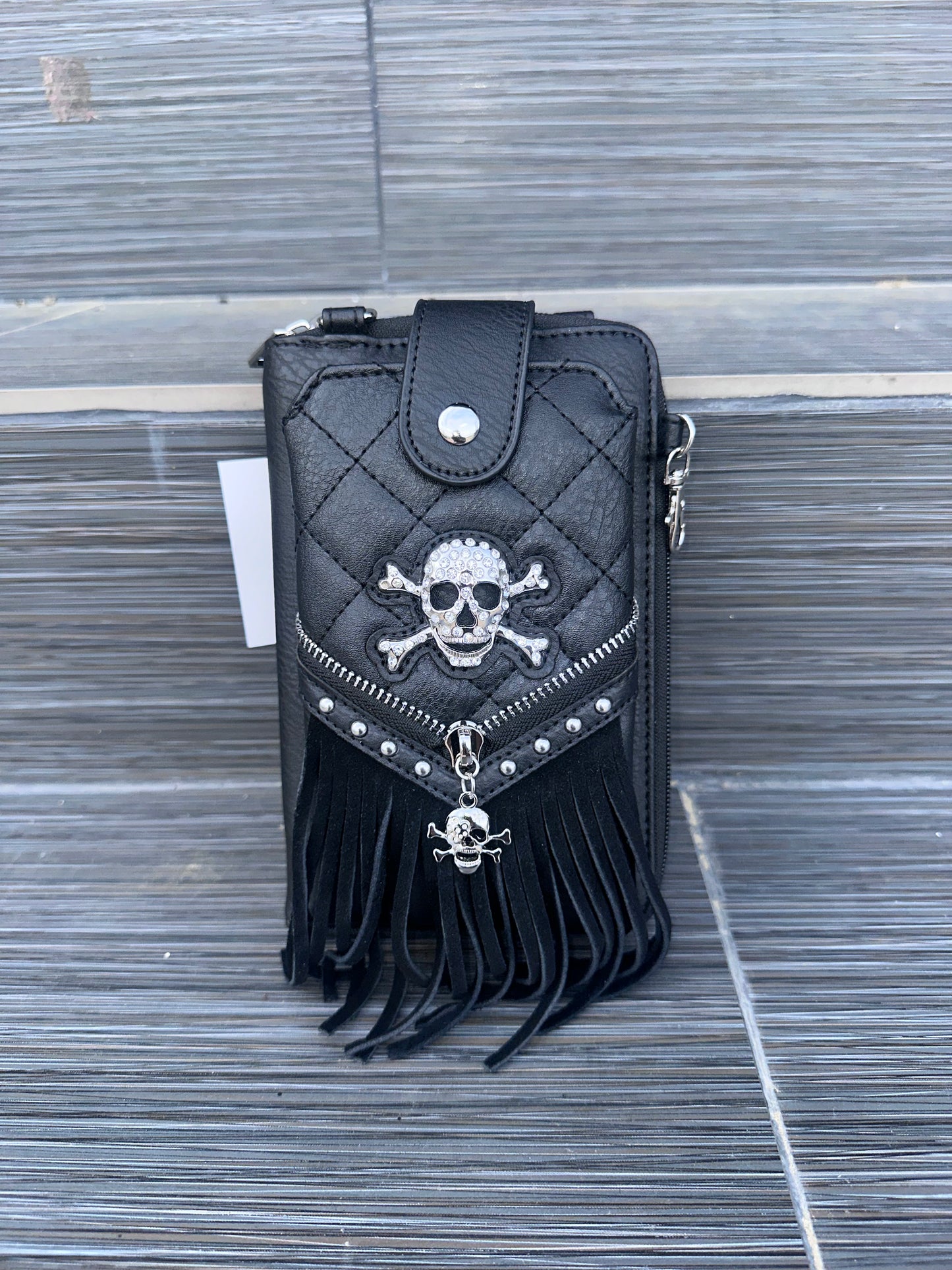 Mini crossbody bag with skull hardware, frills, and front phone pocket