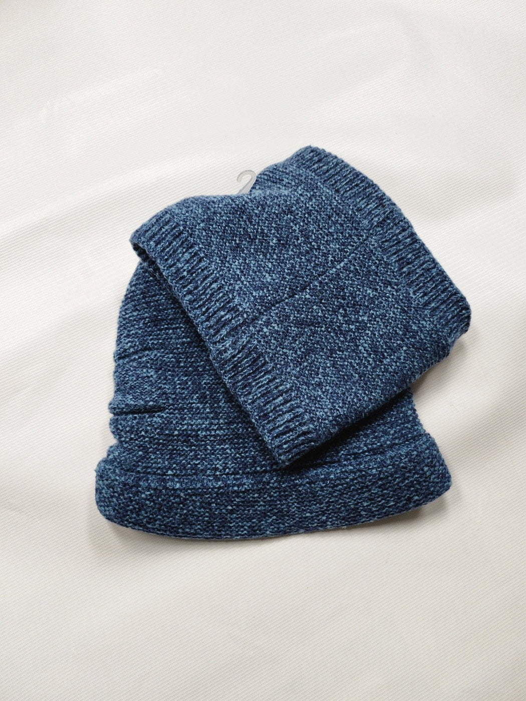 Blue knitted beanie and scarf set on a white background