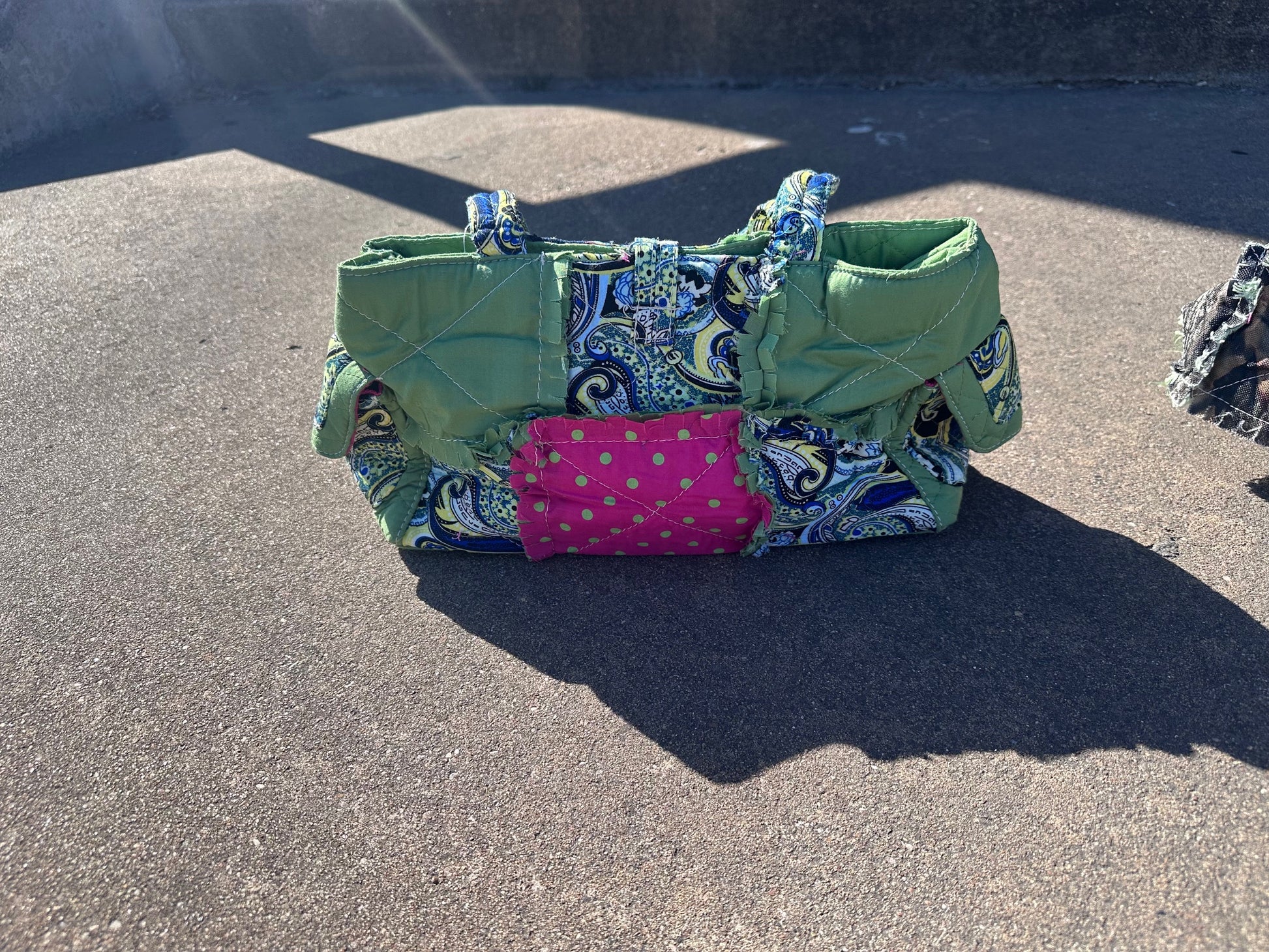 Colorful fabric bag with patterns on a concrete surface