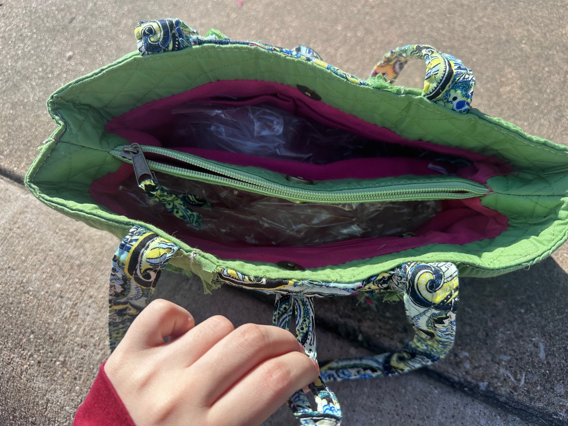 Green fabric bag with colorful patterns on a textured surface