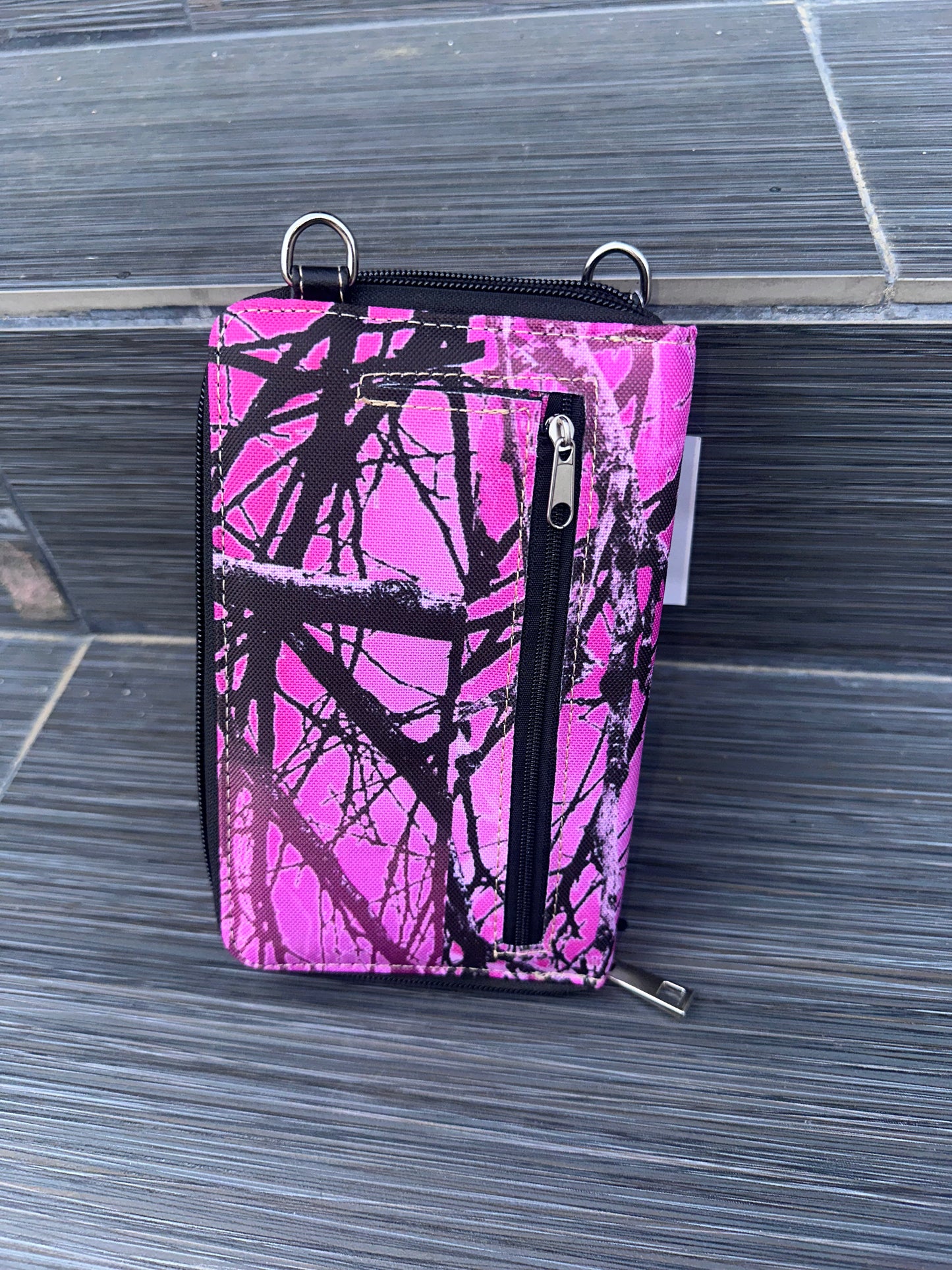 Pink and black camouflage phone case on a textured surface