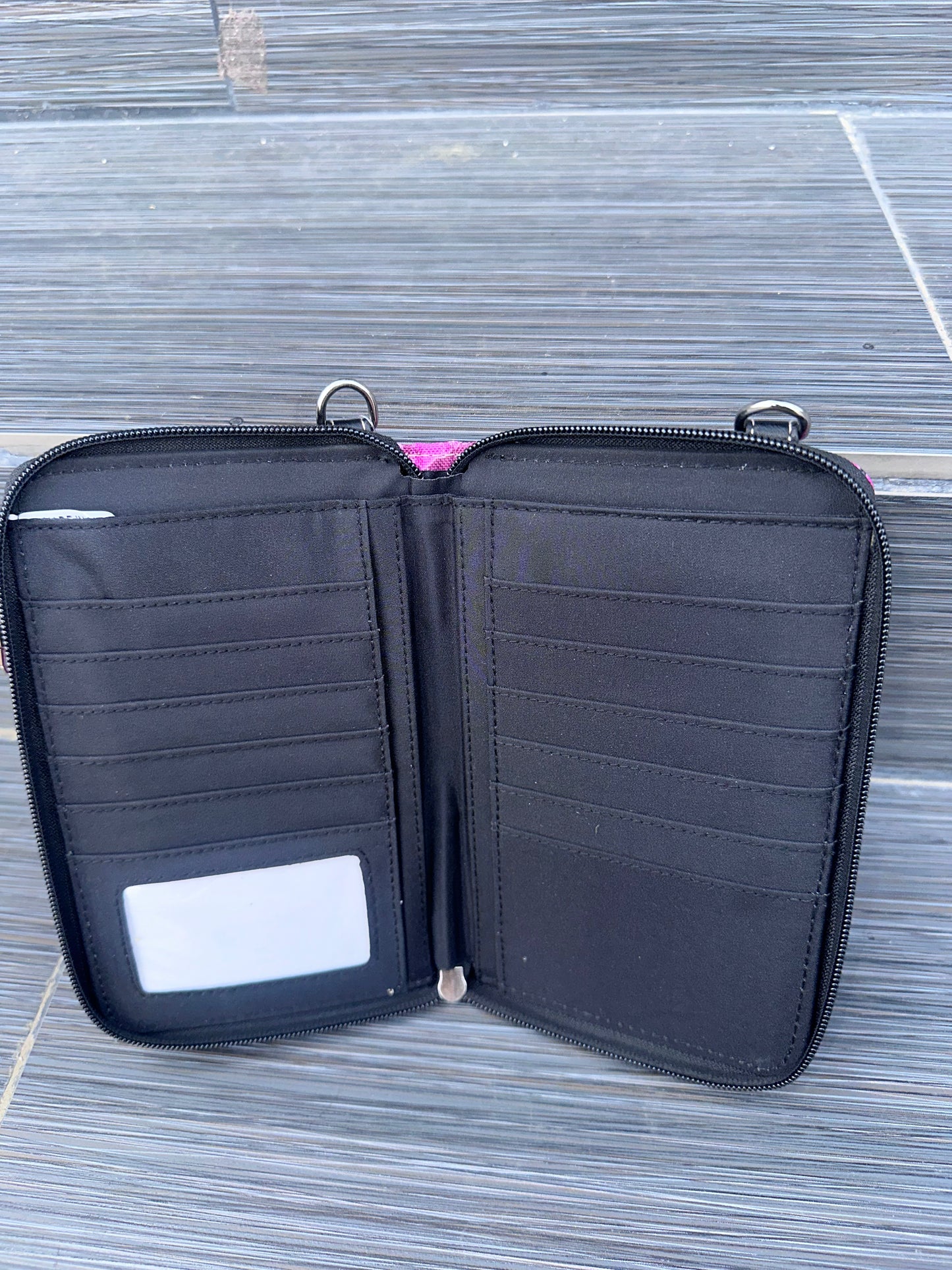 Black zippered pouch with multiple compartments on a textured surface