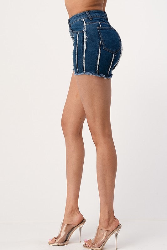Side view of the denim shorts. The shorts display a vertically striped distress pattern.